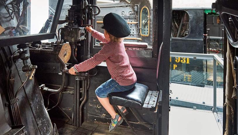 Junge mit Schaffnersmütze im Eisenbahnmuseum
