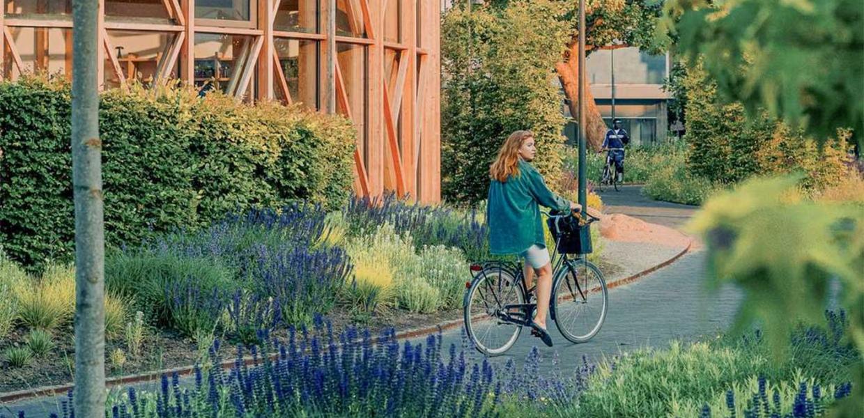 Pige på cykel ved hca hus