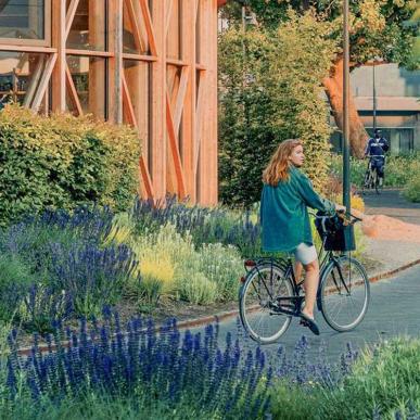 Pige på cykel ved hca hus